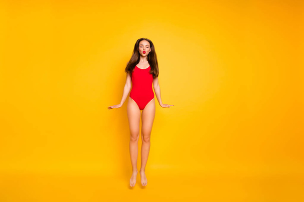 Full length photo of stunning lady nice lifeguard jumping high sending air kiss visitors wear red swim suit isolated yellow background - Fotoğraf, Görsel