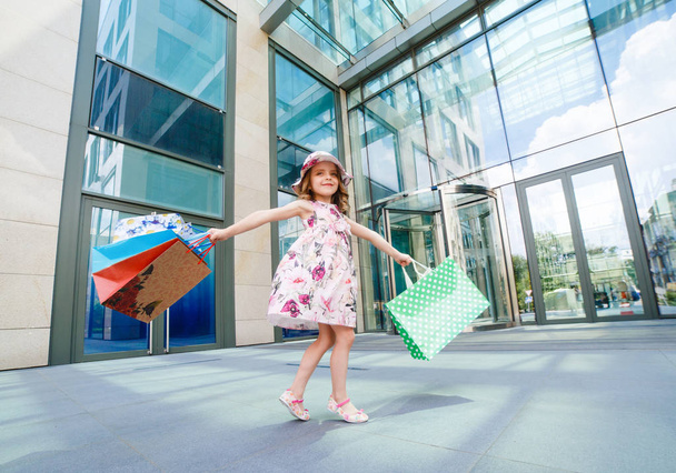 Το χαριτωμένο μικρό κορίτσι για ψώνια. Πορτρέτο του ένα παιδί με τσάντες αγορών. Για ψώνια. Κορίτσι. - Φωτογραφία, εικόνα