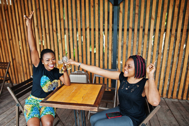Two african american girls drinking and cheering together. - Foto, Imagem