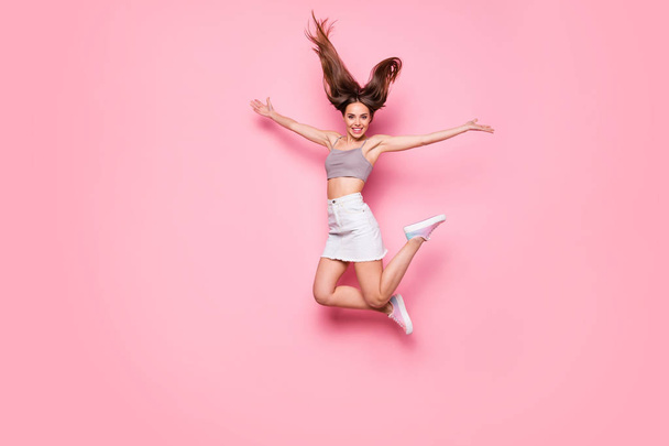 Full body photo of cute millennial person raising hands feeling rejoice wearing gray singlet white skirt isolated over pink background - Foto, imagen