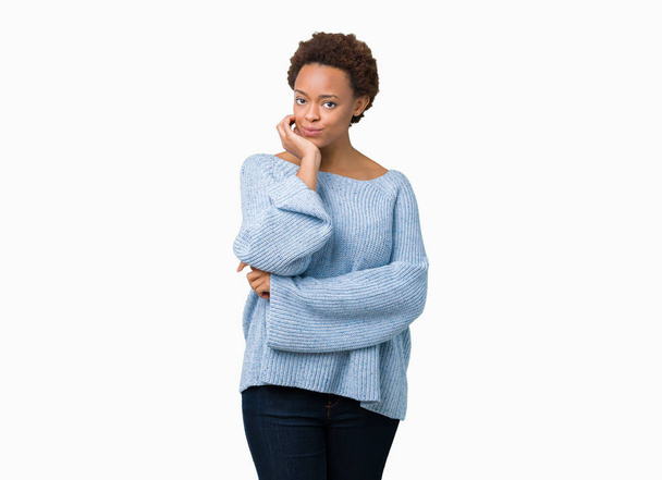 Νέοι όμορφη αφρικανική αμερικανική γυναίκα που φορώντας ένα πουλόβερ πάνω από απομονωμένες φόντο αναζητούν αυτοπεποίθηση στη φωτογραφική μηχανή με χαμόγελο με σταυρωμένα χέρια και χέρι σηκωμένο στο πηγούνι. Σκέφτεστε θετικά. - Φωτογραφία, εικόνα