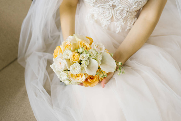 Λευκό και πορτοκαλί γαμήλια ανθοδέσμη στα χέρια της νύφης - Φωτογραφία, εικόνα