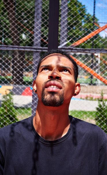 Hombre de etnia negra mirando al aro de baloncesto
 - Foto, imagen