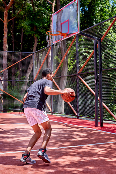 Musta koripalloilija pelaa kentällä
 - Valokuva, kuva