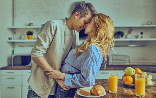 Romantic young couple cooking together in the kitchen, having a great time together.  - Фото, зображення