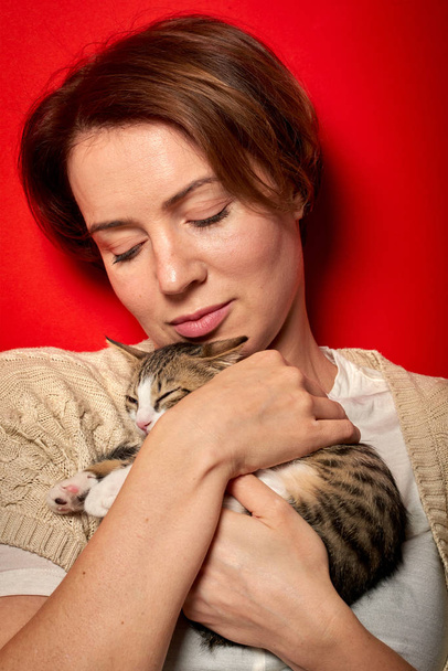 Woman playing with a little cat - Fotografie, Obrázek