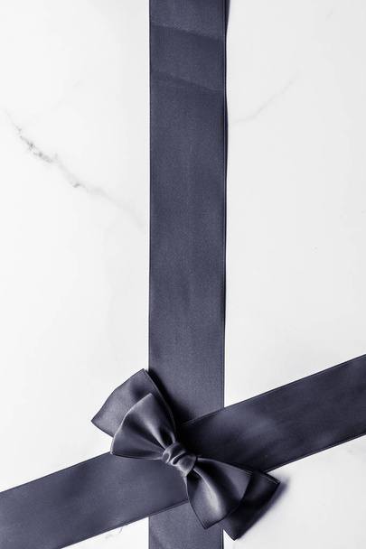 Black silk ribbon and bow on marble background, flatlay - Valokuva, kuva