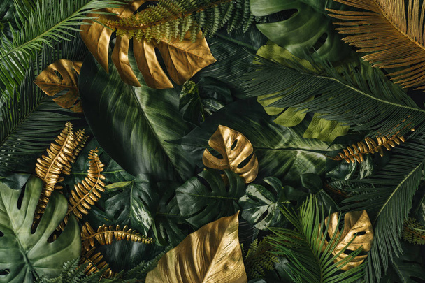Kreatywne tło natury złota i zielonych tropikalnych liści palmowych. Minimalny letni abstrakcyjny wzór dżungli - Zdjęcie, obraz