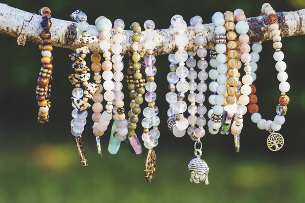 Collezione di bracciali in pietra minerale perline su sfondo naturale all'aperto
 - Foto, immagini