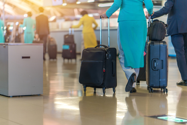 Γυναίκα ταξιδιώτης βόλτα μεταφέροντας μια βαλίτσα στο αεροδρόμιο  - Φωτογραφία, εικόνα