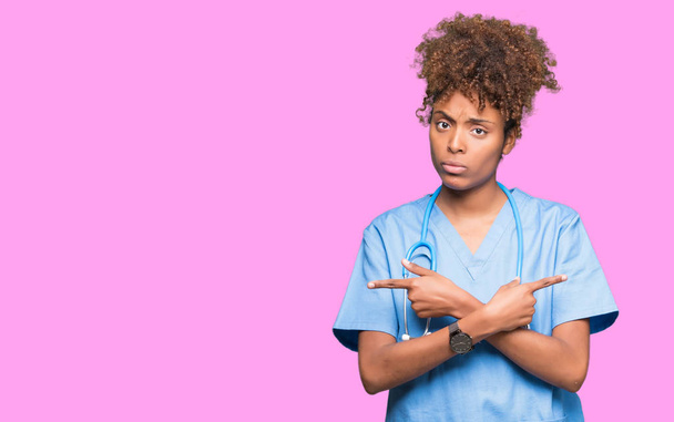 Mladý americký lékař ženu izolované pozadí ukázání na obě strany s prsty, jiným směrem nesouhlasí - Fotografie, Obrázek