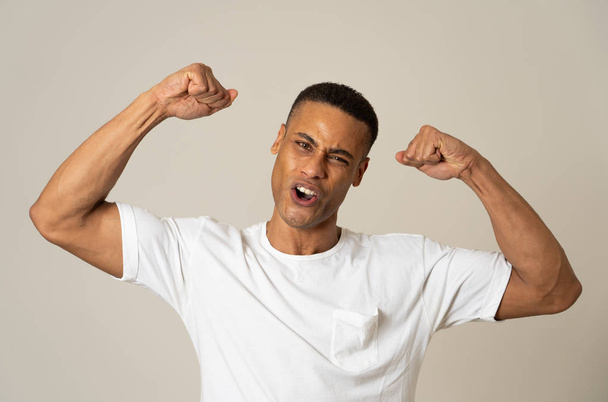 Young strong handsome african american man showing arms muscles smiling proud having fun. In people, Happiness, Fitness, success Human emotions and facial expressions concept. - Foto, Bild