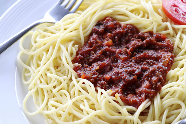 Spaghetti z sosem pomidorowym i mięsem mielonym. Spaghetti z sosem pomidorowym na białej płytce. - Zdjęcie, obraz