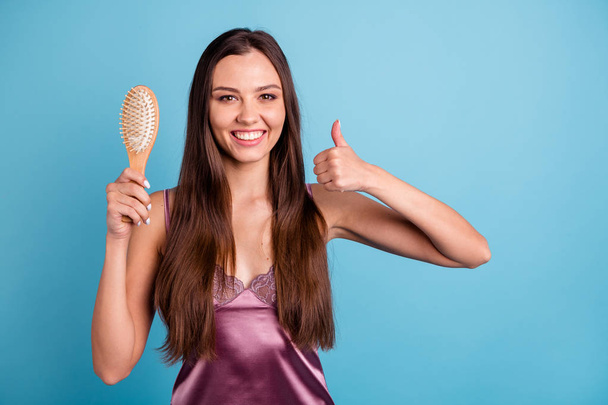 Portrait of her she nice-looking attractive lovely well-groomed pretty cheerful cheery girl demonstrating new comb showing thumbup isolated over bright vivid shine teal blue green turquoise background - Foto, imagen