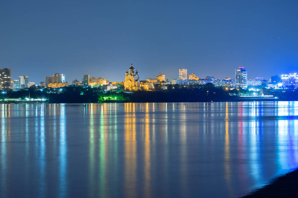 Night View of the city of Khabarovsk from the Amur river. Blue night sky. The night city is brightly lit with lanterns. - Photo, Image