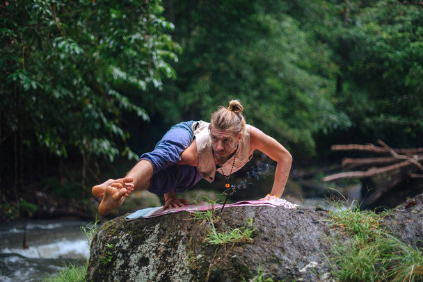 Praktyka jogi i medytacja w przyrodzie. Człowiek praktykujący w pobliżu rzeki - Zdjęcie, obraz