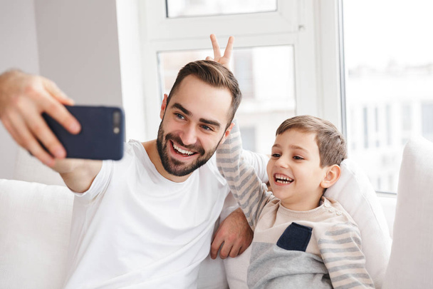 Happy father having fun with his son and making selfie - Foto, Bild