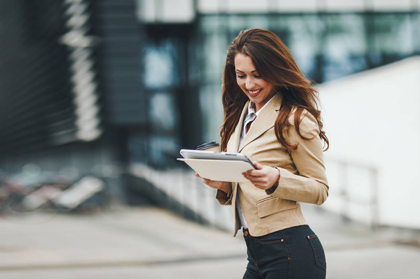 young businesswoman holding tablet on urban city background - Foto, immagini