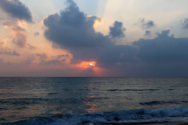The sun sets over the horizon on the Mediterranean Sea in northern Israel and night falls  - Fotó, kép