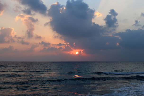 The sun sets over the horizon on the Mediterranean Sea in northern Israel and night falls  - Photo, Image