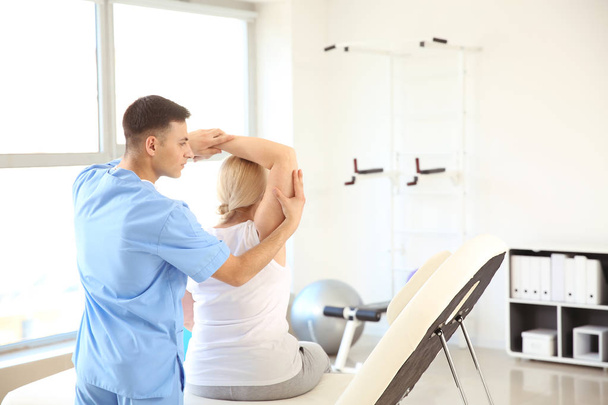 Physiothérapeute travaillant avec un patient mature dans un centre de réadaptation
 - Photo, image