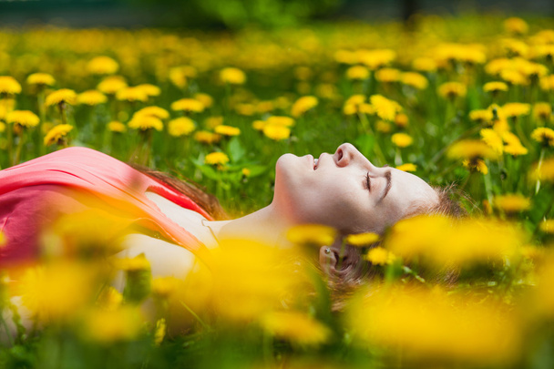 beautiful girl lying on the field of dandelions - Fotoğraf, Görsel