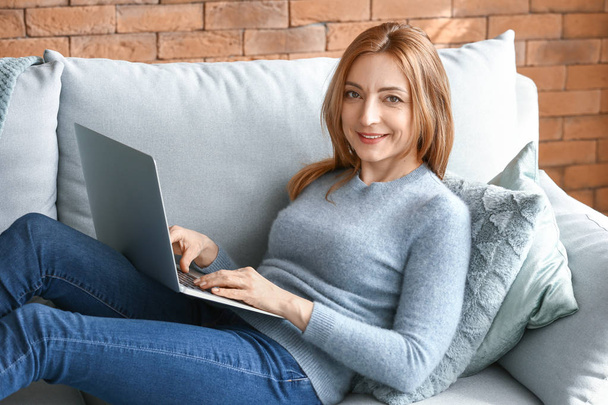 Retrato de mujer madura trabajando en el ordenador portátil en casa
 - Foto, imagen