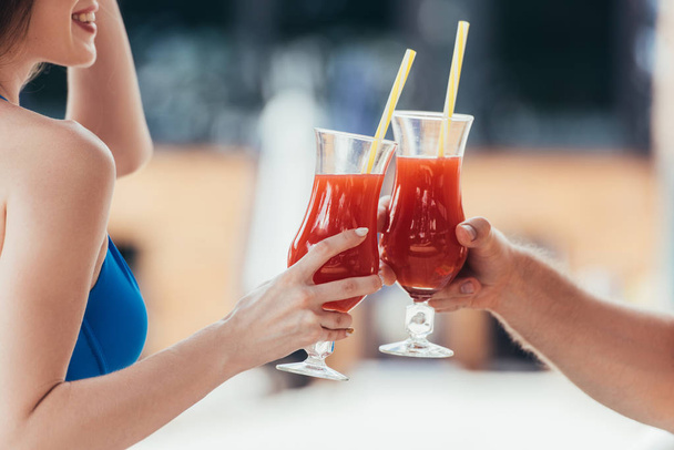 cropped view of smiling young woman clinking glasses of refreshing drink with boyfriend - Photo, Image
