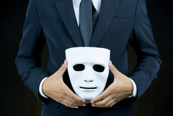 businessman hide the white mask in the hand behind his back on b - Фото, зображення