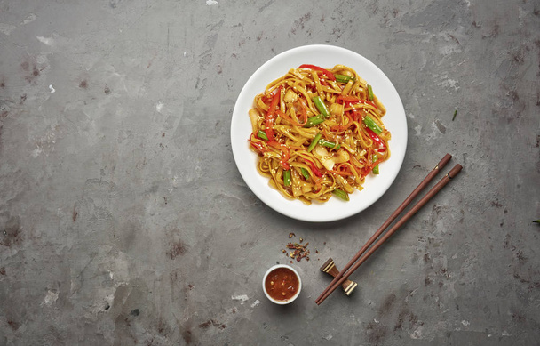 Chinese noodles with beef and vegetables on grey stone background .Top view, copy space - Valokuva, kuva