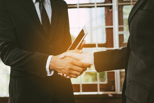 dos hombres de negocios estrechando la mano en el lugar de trabajo
 - Foto, imagen