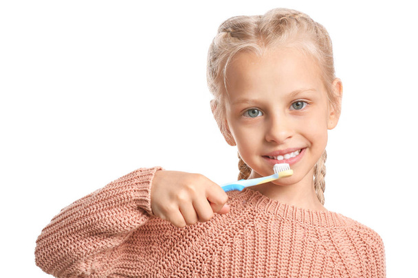 Μικρό κορίτσι καθαρισμού δόντια σε λευκό φόντο - Φωτογραφία, εικόνα