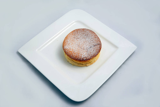 Pieni kontrasti Hero Laukaus pannulla kakku lautasella, on minimaalinen valkoinen tausta lävistäjä 60 asteen kulmassa
 - Valokuva, kuva