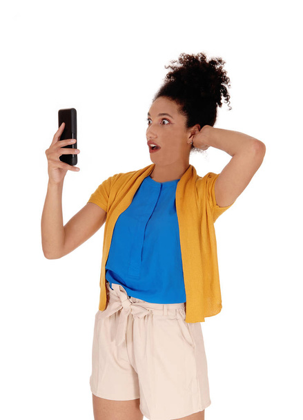 Mulher multi-racial chocado olhando para o seu telefone celular
 - Foto, Imagem