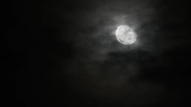 Zeitraffer-Bewegung Krater auf der Oberfläche des Vollmondes Am dunklen Himmel und den schwarzen Wolken in der Nacht. - Filmmaterial, Video