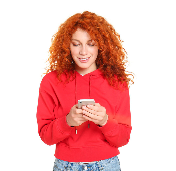 Beautiful redhead woman with mobile phone on white background - Photo, Image