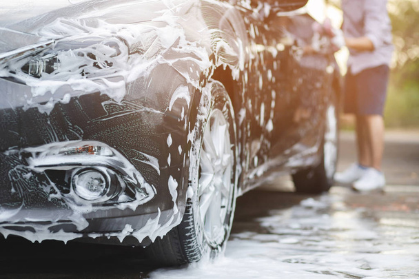 Lavado de coches al aire libre con jabón de espuma activa. limpieza comercial lavado concepto de servicio
. - Foto, Imagen