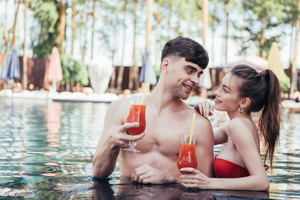 two glasses with natural fruit refreshing beverage at poolside - Foto, imagen