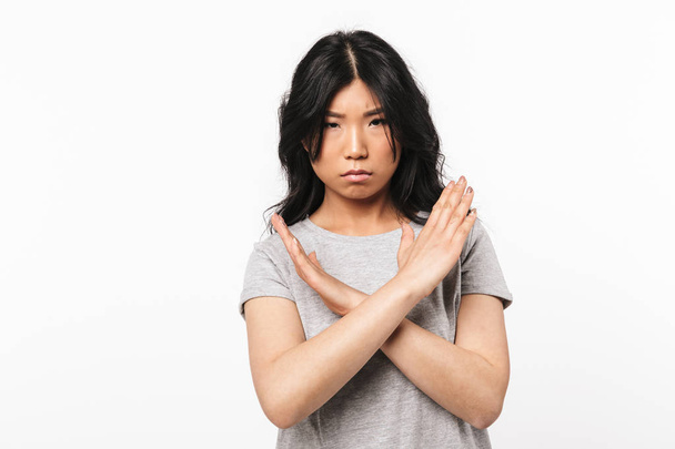 Serious asian beautiful young woman posing isolated over white wall background showing stop gesture. - Foto, Bild