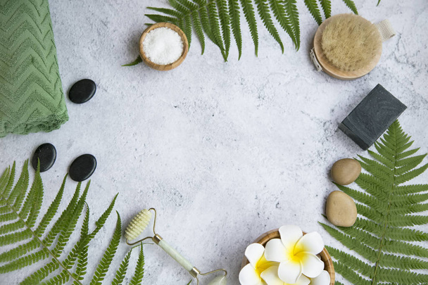 Green botanical spa flatlay with fern, charcoal soap, massage st - Foto, imagen