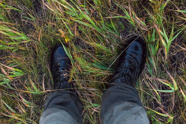 Sonbahar çim gonzo aşağı bakış açısı ıslak siyah ordu botları ve yeşil pamuk pantolon Ayaklar. - Fotoğraf, Görsel