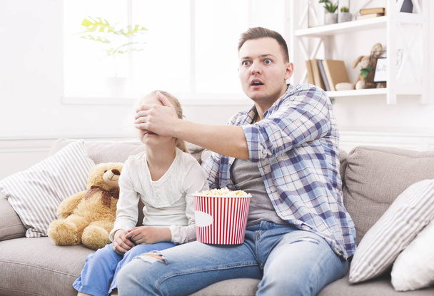 Father is closing his daughter eyes while watching movie - Fotó, kép