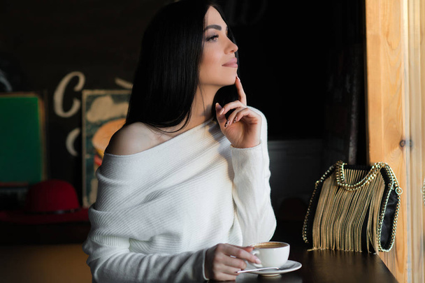 dreaming brunette woman in cafe with cup of coffee - Φωτογραφία, εικόνα