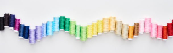 панорамный снимок ярких и красочных нитей на белом фоне
  - Фото, изображение