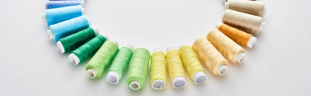 panoramic shot of bright and colorful threads on white background  - Foto, Imagen