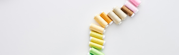 plano panorámico de hilos brillantes y coloridos sobre fondo blanco
  - Foto, imagen