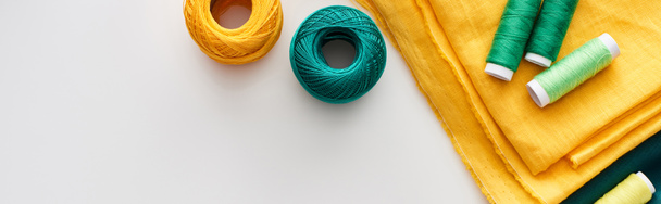 白い背景に生地、編み糸のボールと糸のパノラマショット  - 写真・画像