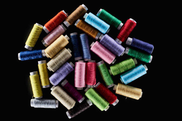 top view of bright and colorful threads isolated on black - Foto, immagini