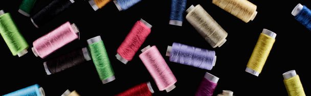 panoramic shot of bright and colorful threads isolated on black - Foto, imagen