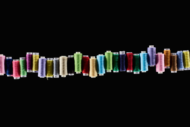top view of bright and colorful threads isolated on black - Photo, Image